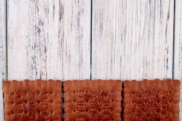 top view Chocolate crackers on the bottom with copy space on white wooden background