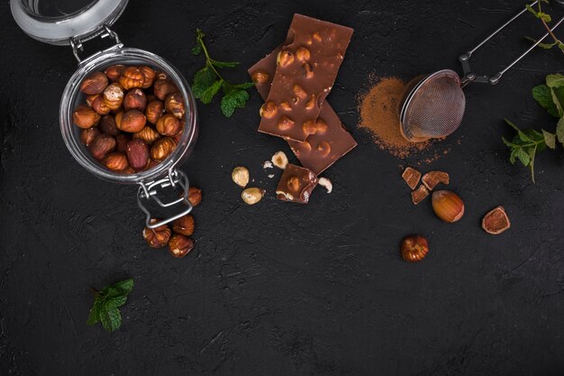 Top view chocolate and jar with hazelnuts