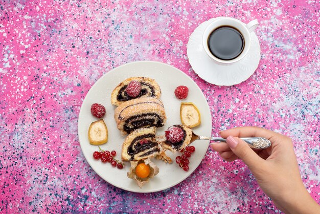 紫のデスクケーキ砂糖甘い生地焼きにコーヒーのカップと白いプレート内のトップビューチョコレートロールケーキ