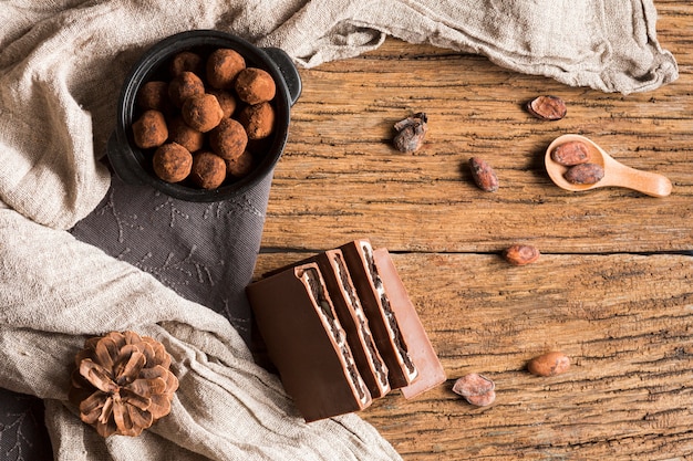 Top view chocolate truffles in bowl and chocolate bar