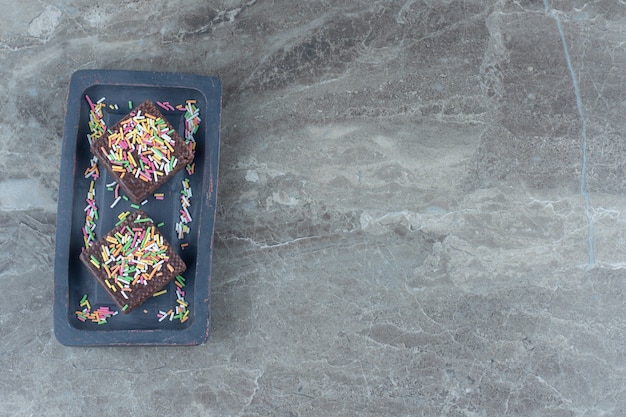 Top view of chocolate wafers on grey wooden board.