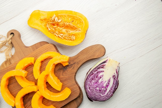 Top view chopped butternut squash on wood boards cut red cabbage on grey table