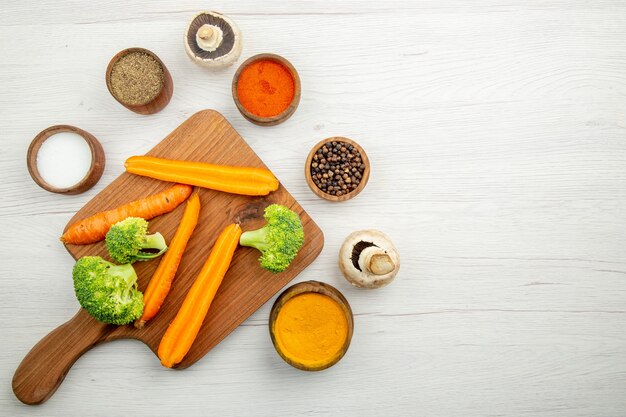 Top view chopped carrots and broccoli on chopping board