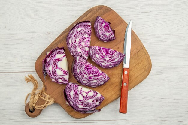 Top view chopped red cabbage knife on wooden board on grey table