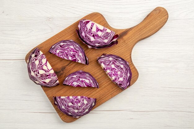 Top view chopped red cabbages on cutting board on white surface