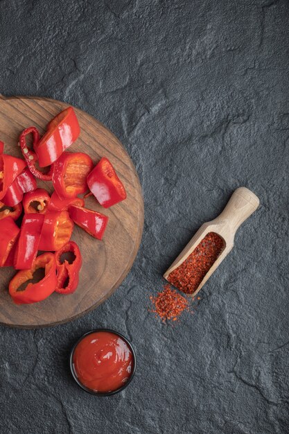 Top view of chopped red pepper with peppercorn and ketchup.