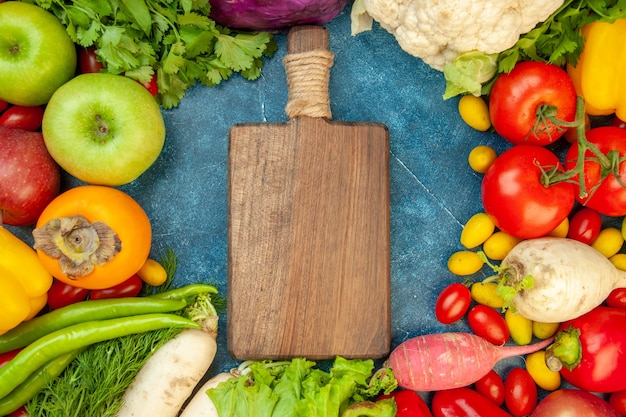 Top view chopping board red cabbage cherry tomato dill coriander parsley radish apples lettuce cauliflower bell peppers persimmons