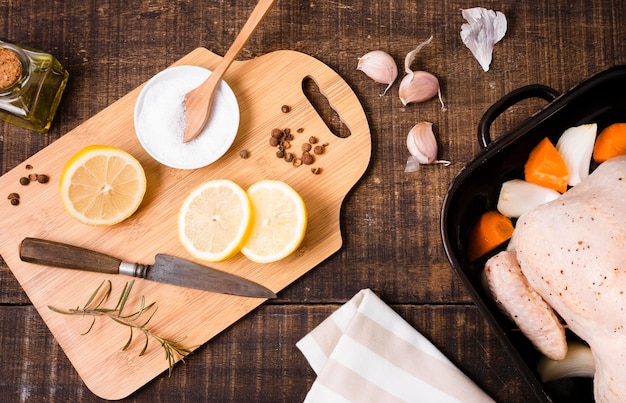 Top view of chopping board with lemon slices and chicken