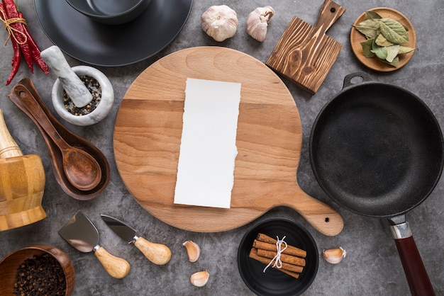 Top view of chopping board with paper menu and pan