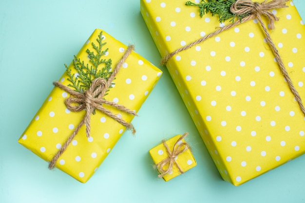 Top view of Christmas background with yellow gift boxes in different sizes on pastel green background