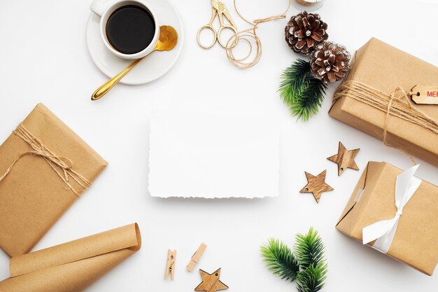 Top view of Christmas composition with gift box, ribbon, fir branches, cones, anise on white table