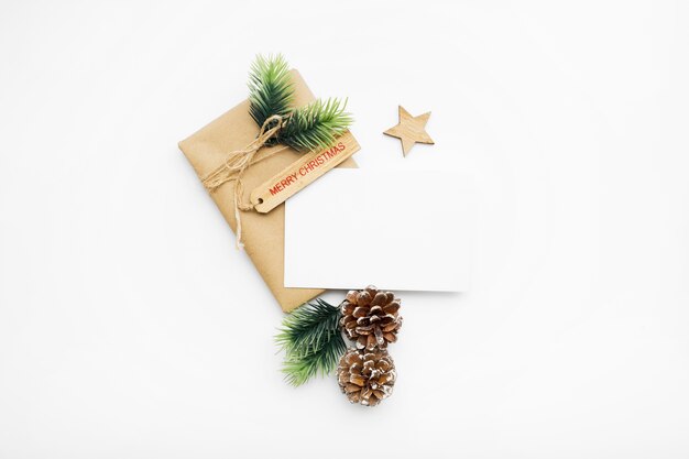 ギフトボックス、リボン、モミの枝、コーン、白いテーブルの上のアニスとクリスマスの構成の上面図