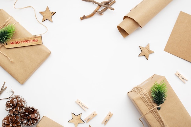 Top view of Christmas composition with gift box, ribbon, fir branches, cones, anise on white table