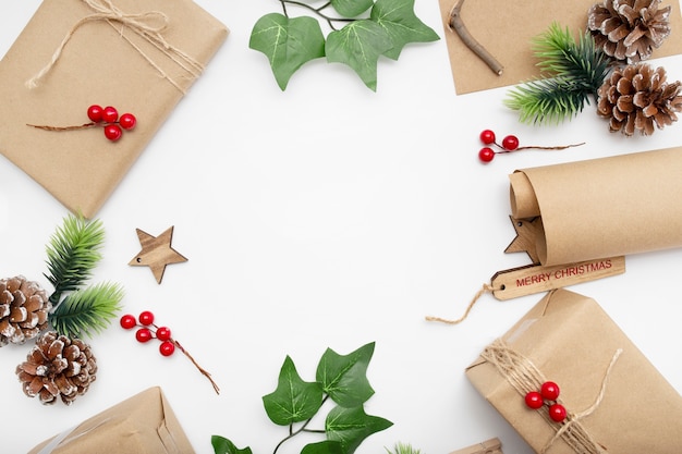 Top view of Christmas composition with gift box, ribbon, fir branches, cones, anise on white table