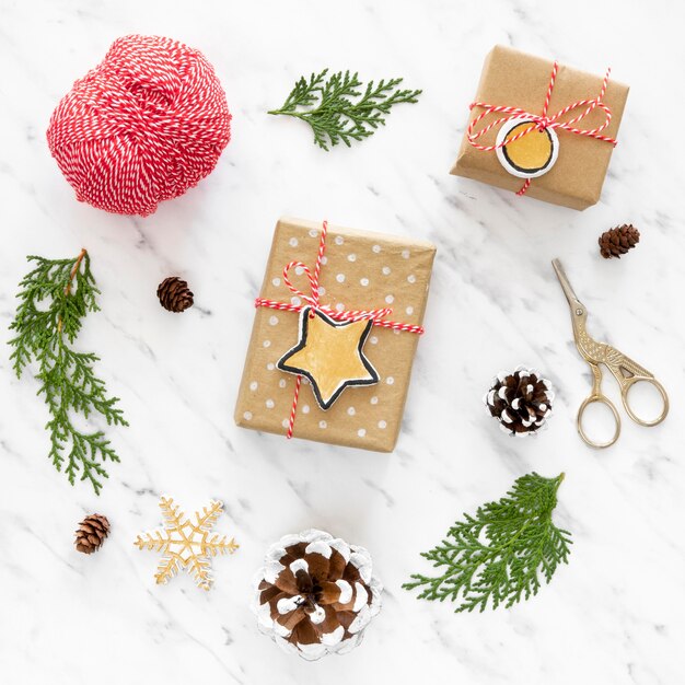 Top view of christmas gifts with pine cone and scissors