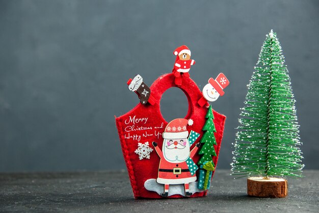 Top view of christmas mood with decoration accessories on new year gift box and xsmas tree on dark surface