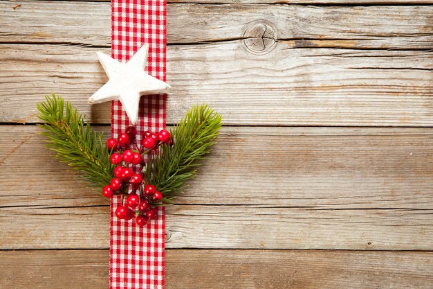 Top view of Christmas ornaments with berries and tree branches on a wooden surface