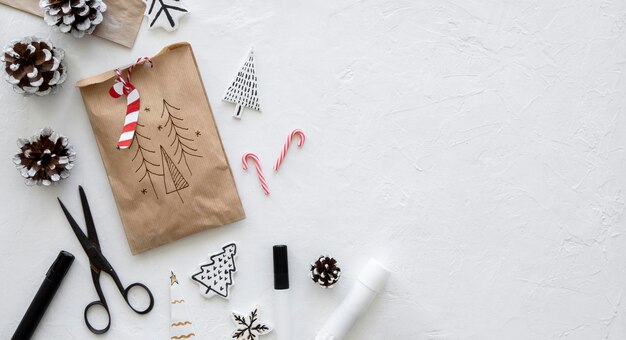 Вид сверху на рождественский бумажный пакет с ножницами и копией пространства