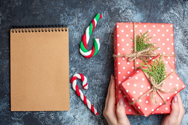 Top view christmas presents, candy cane and empty notebook