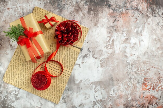 Рождественские подарки с красными шишками на светлом фоне