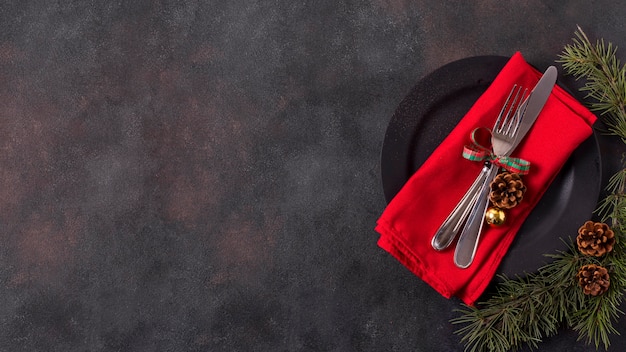 Top view of christmas table arrangement with pine cones and cutlery