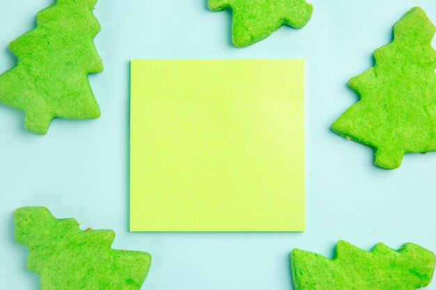 Top view christmas tree figures little sweets with sticker on a blue background