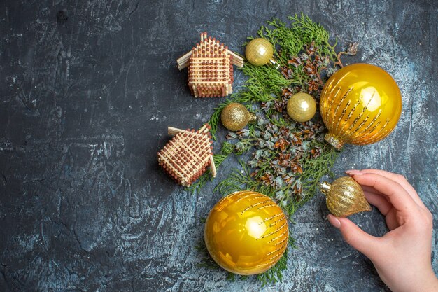 Top view christmas tree toys with green branch on light-dark background