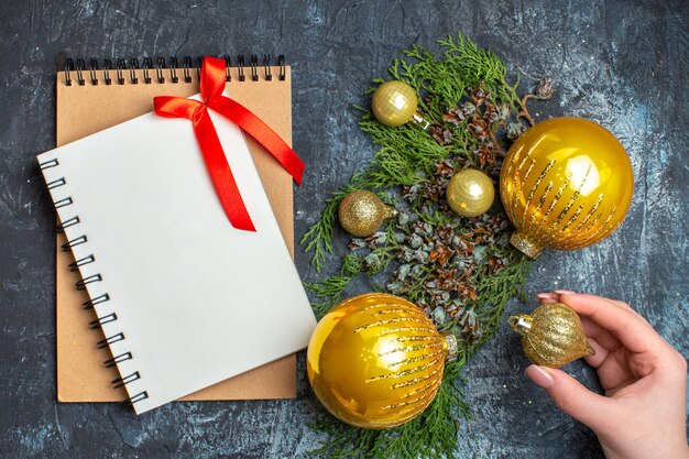 Top view christmas tree toys with notepad on light-dark background