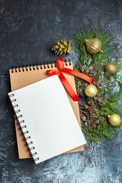 Top view christmas tree toys with notepad on light-dark background