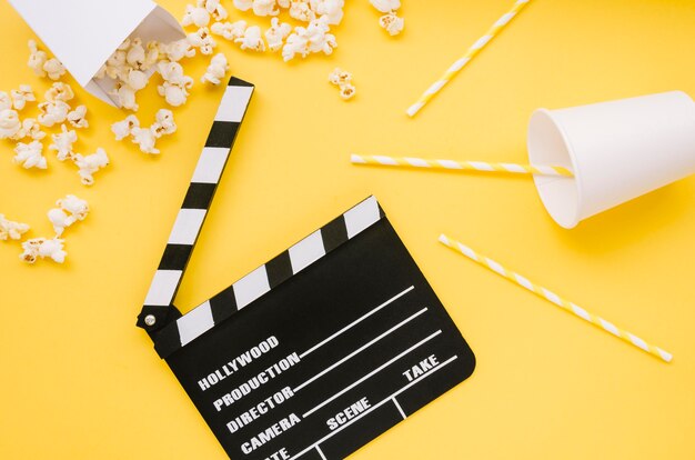 Top view cinema clapperboard with popcorn