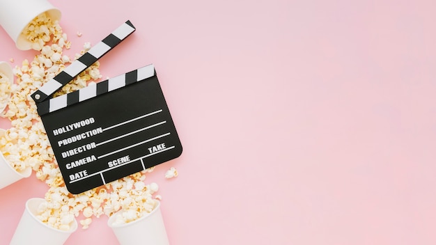 Top view cinema clapperboard with popcorn