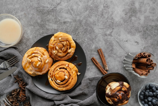 Free photo top view cinnamon roll and sticks