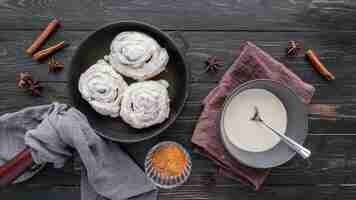 Free photo top view cinnamon rolls with cream