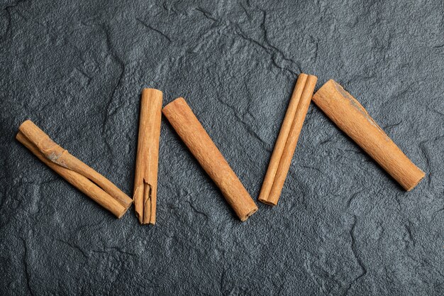 Top view of cinnamon sticks isolated on dark background. 