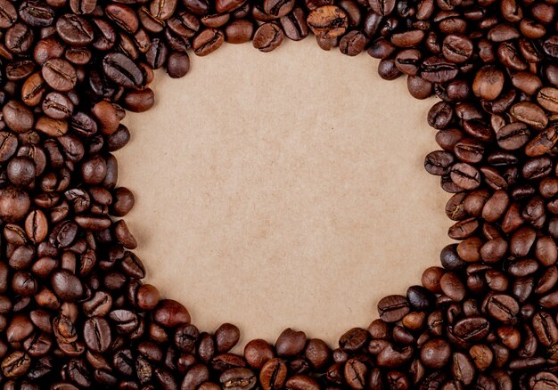 top view of circle coffee beans on brown paper texture background