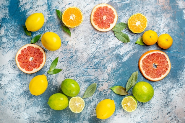 Вид сверху круговой ряд цитрусовые лимоны грейпфруты мандарины на синем белом столе