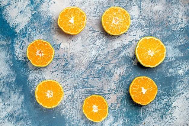 Top view circle row cut oranges on blue white table