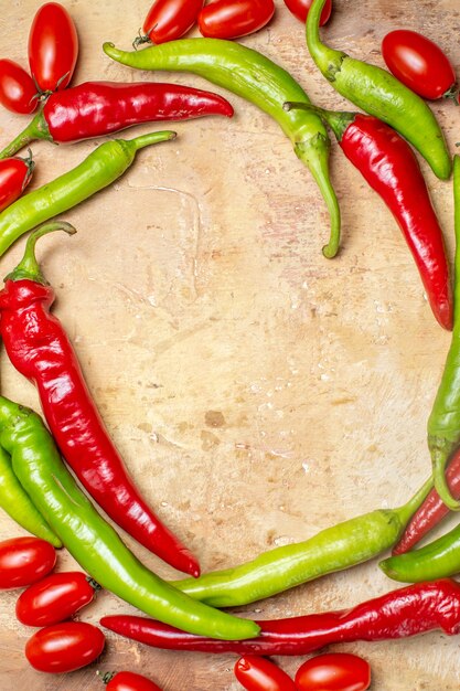 Free photo top view circle shape hot peppers and cherry tomatoes on amber background