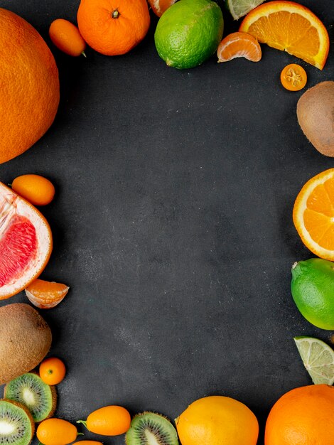 Top view of citrus fruits as tangerine lime and others on black surface