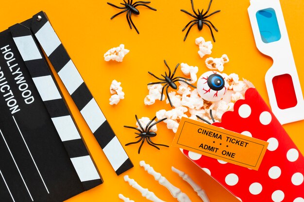 Top view clapperboard with popcorn and spiders