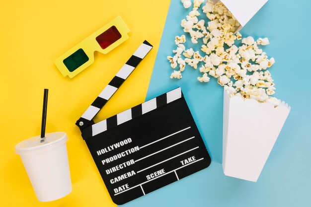 Top view clapperboard with popcorn on the table