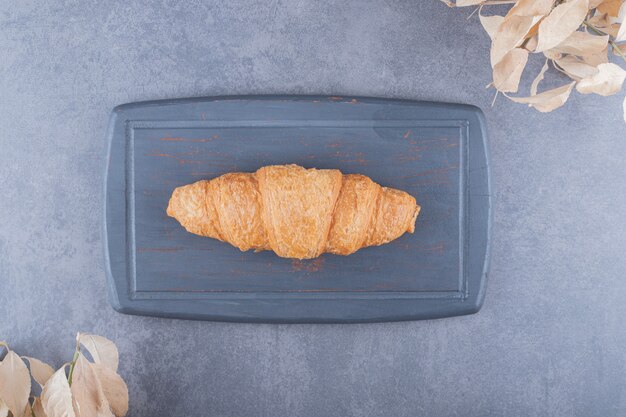 Top view of classic French croissant on grey wooden board