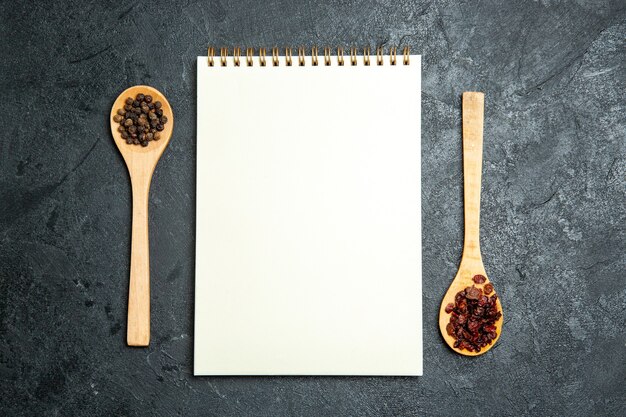 Top view clean notepad with spoons on grey space