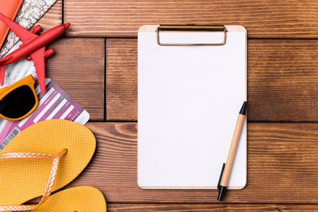 Top view clipboard surrounded by beach slippers