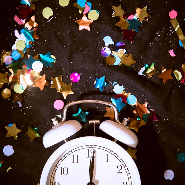 Free photo top view clock surrounded by colorful confetti