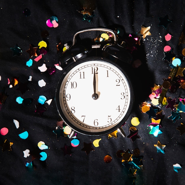 Free photo top view clock with colorful confetti