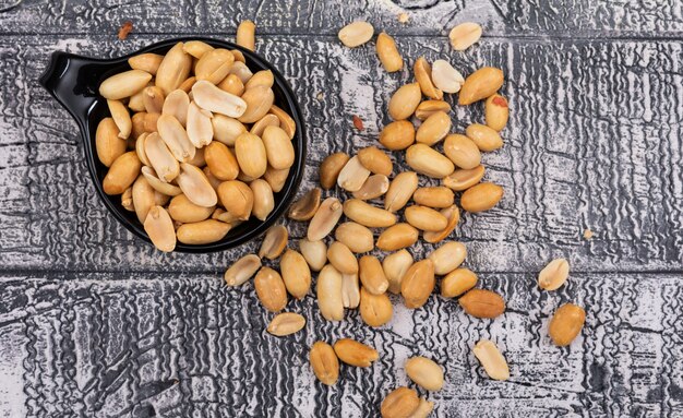 Top view close-up peanuts in bowl on wooden gray  horizontal