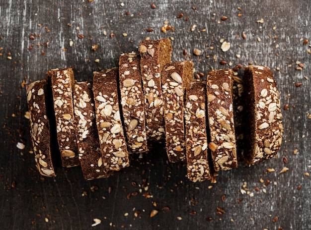 Foto gratuita fette del primo piano di vista superiore di pane integrale e di fondo di legno