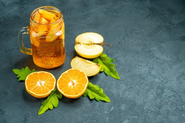 Top view cocktail cut oranges and apples on dark isolated background