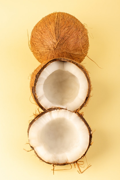 Free photo a top view coco nuts sliced milky fresh mellow isolated on the cream colored